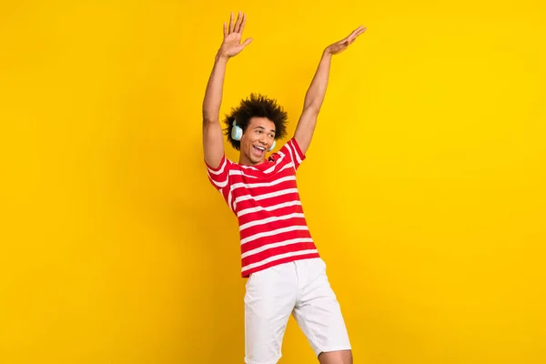クールな陽気な男の写真は 縞模様のTシャツは楽しい孤立した黄色の背景を持つヘッドフォンを聞いて着用 — ストック写真