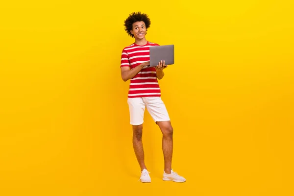 明るいです長さの写真かわいい男の着用ストライプTシャツワーキング現代デバイス隔離された黄色の背景 — ストック写真
