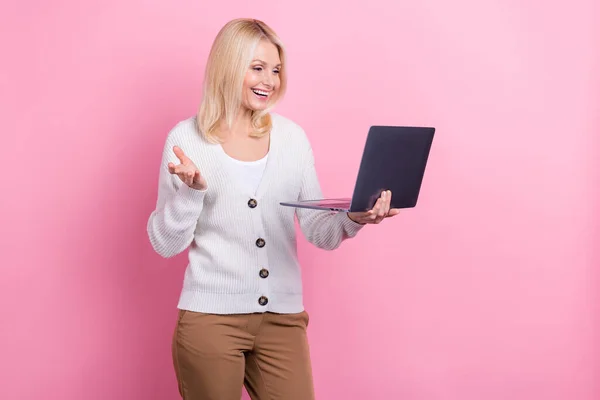 Portrait of optimistic satisfied person blond hair dressed white sweater look at laptop talk video call isolated on pink color background.