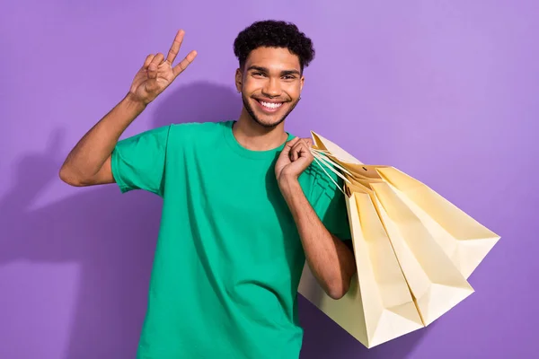 魅力的なフレンドリーな男性の写真は Vサイン保持バーゲン孤立紫色の背景を示す緑のTシャツを着用 — ストック写真