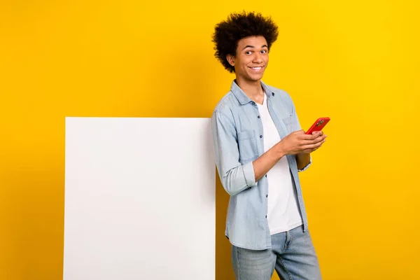 照片中快乐的年轻人用智能手机聊着空旷的空间海报 用黄色背景隔开 — 图库照片