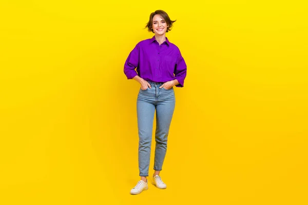 Full body photo of cheerful businesswoman wear violet shirt denim jeans posing for magazine formal clothes isolated on yellow background.