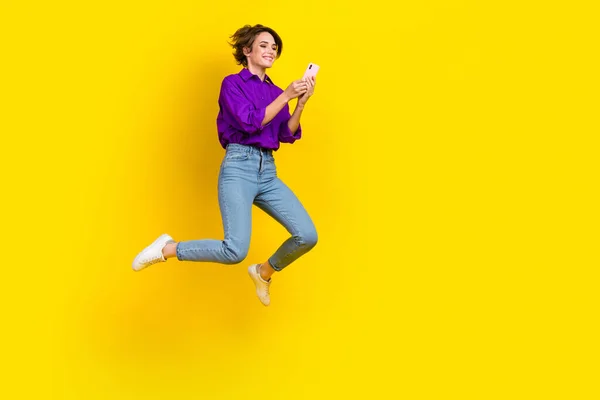 甘いですかわいい女性の完全な長さの写真は紫のシャツジャンプチャットサムスンのIphoneアップルデバイス隔離された黄色の背景 — ストック写真