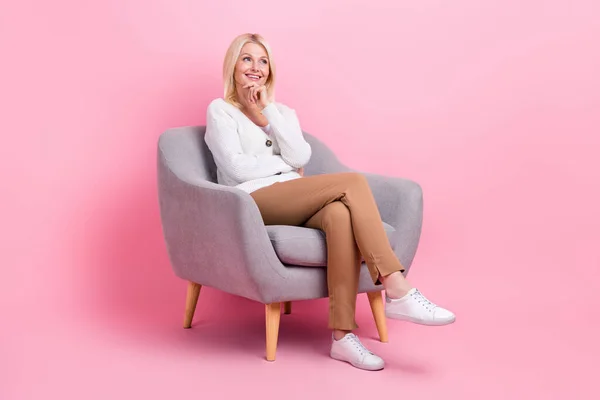 明るい創造的な心の女性の完全な長さの写真座っている椅子の腕のタッチあごはピンクの色の背景に隔離された空のスペースに見える — ストック写真