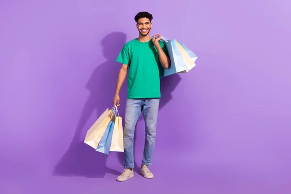 フルボディ長いです写真の若いですShopaholic面白い男ホールドバッグから新しいショッピングモール多くの購入隔離された上で紫色の背景 — ストック写真