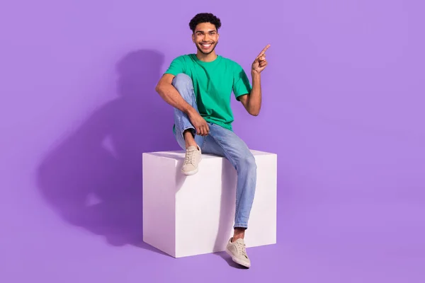 指を指揮する若い男の完全な長さの写真空のスペース便利なヒントは 紫色の背景に隔離されたプラットフォームブランドのプロモーターに座る — ストック写真