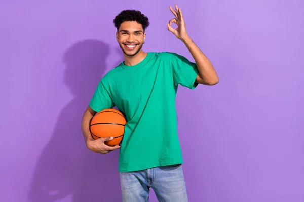 농구공을 잘생긴 남자의 사진은 보라색 배경에 표시된 기호를 보여준다 — 스톡 사진