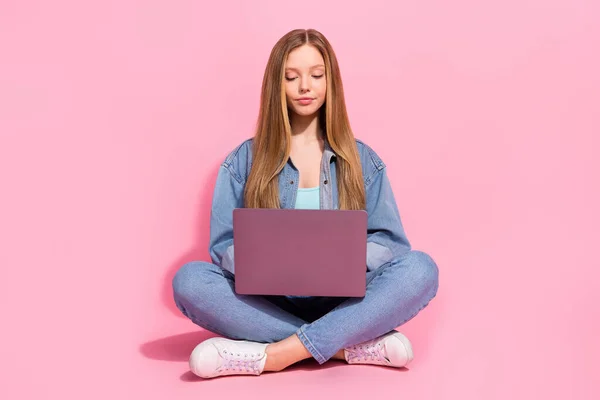 可愛い女の子の写真は ピンクの色の背景に隔離された宿題を書くオンラインレッスンを聞いて床に座ってスタイリッシュな服を着る — ストック写真