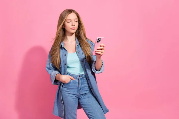 可愛い豪華な女の子中毒ユーザーの肖像は スタイリッシュなデニム服を着用ピンクの色の背景に隔離されたIphoneスタンド空のスペースを使用 — ストック写真