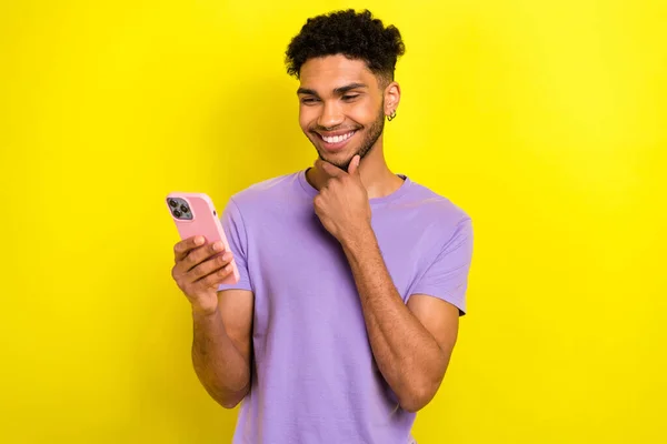 漂亮而积极的年轻人的画像 手臂触摸下巴 笑容满面 用黄色背景的智能手机隔开 — 图库照片
