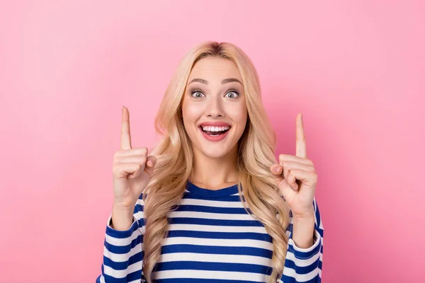 stock image Portrait of impressed overjoyed girl curly hairstyle striped pullover indicating up empty space offer isolated on pink color background.