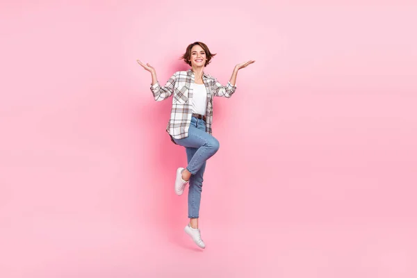 全尺寸的漂亮女孩跳跃的肖像举手空旷的空间隔离在粉红色的背景下 — 图库照片