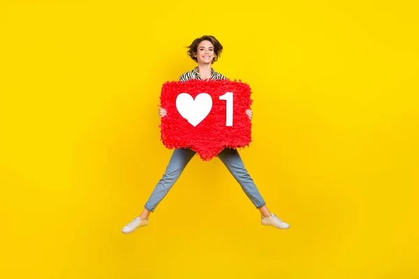 stock image Full length photo of cool pretty lady wear animal print shirt rising heart pinata jumping high isolated yellow color background.