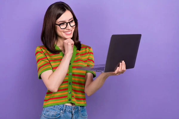 聪明聪明的女士穿着时髦衣服的照片拿着上网本使用现代技术观看紫色背景的视频 — 图库照片