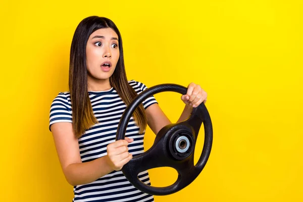 照片上年轻害怕滑稽的日本女孩拿着方向盘害怕紧张麻木的道路撞车事故被黄色背景隔离 — 图库照片