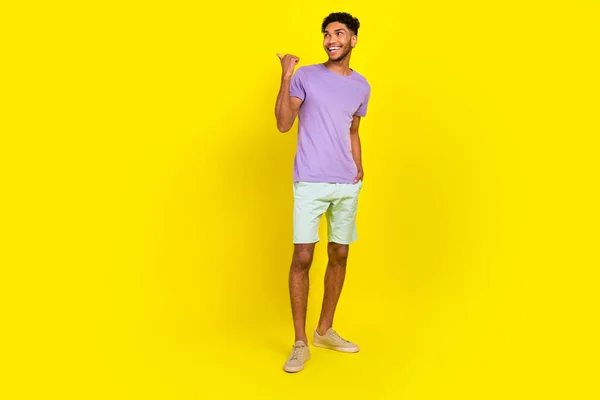 年轻广告商指指指点点空旷的地方穿着时髦的夏装在黄色背景下进行销售的全长体照片 — 图库照片