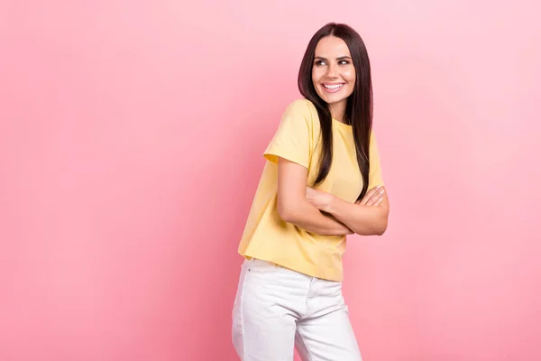写真かわいい女性ホールド腕クロス見て空のスペース広告黄色のシャツ白いジーンズパンツ服孤立ピンク色の背景 — ストック写真
