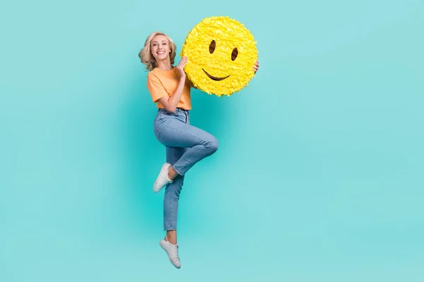 길이의 귀여운 여자가 주황색 티셔츠를 점프하는 모습이 포스터빈 공간에 외따로 — 스톡 사진