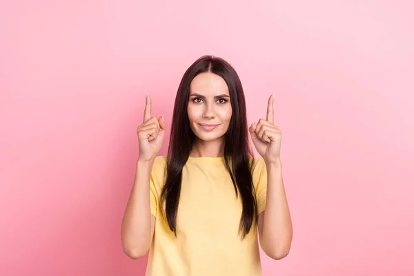 stock image Photo of adorable cute lady wear yellow t-shirt pointing two fingers up empty space isolated pink color background.