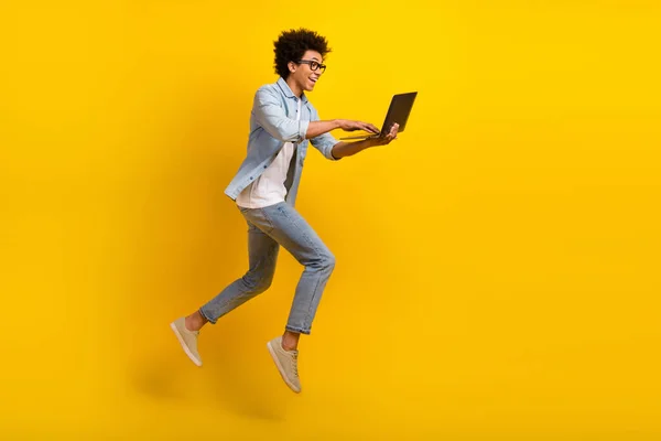 フルサイズプロファイルのポルノの興奮クレイジー男ジャンプラッシュ使用Netbook絶縁上の黄色の背景 — ストック写真