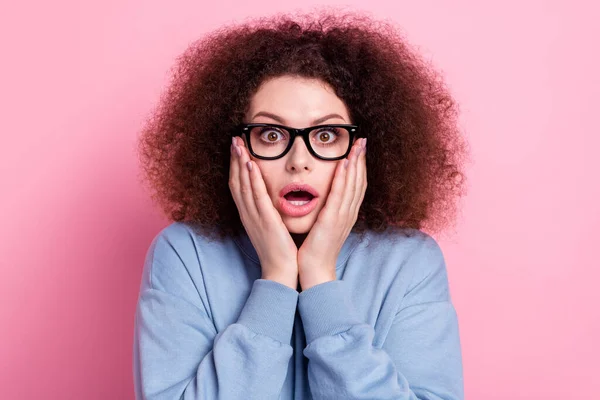 Photo of excited funky lady dressed blue pullover eyewear open mouth arms cheeks isolated pink color background.