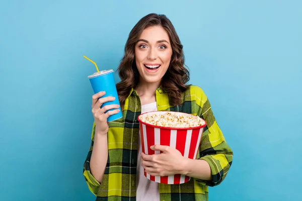 ファンキーな印象の女性の服を着た再生シャツを見て面白い映画ポップコーン飲料ソーダ隔離された青の色の背景を食べる — ストック写真