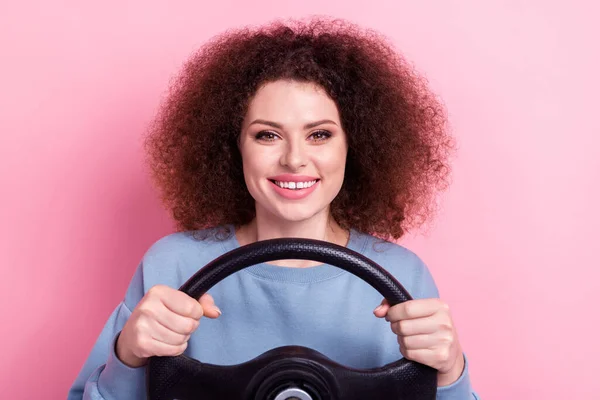 迷人的女士波浪式发型 身穿蓝色运动衫 手握方向盘 在粉色背景下与新车隔离的形象 — 图库照片