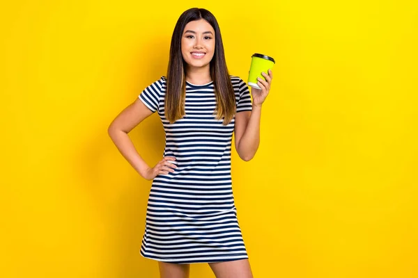 かなり陽気な満足した女性の写真スタイリッシュな服を着て紙コップを保持黄色の色の背景に隔離おいしいアイスコーヒーを飲む — ストック写真
