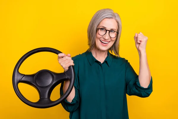 Photo of aged lady driver ride fast speed auto win raise fist up isolated vivid color background.