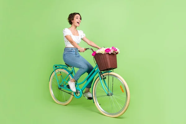 興奮したファンキーな女性の完全な長さの写真は 高速自転車孤立緑の背景に乗って白いトップを身に着けて — ストック写真