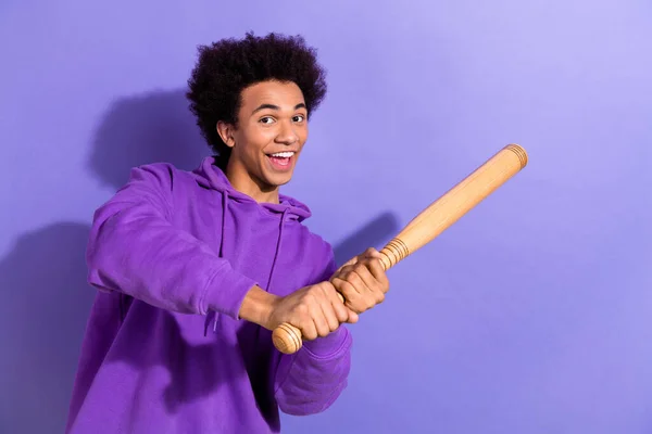 Photo of excited positive person have good mood hands hold baseball bat hit ball isolated on violet color background.