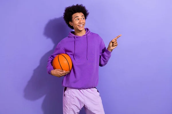 농구공을 잘생긴 긍정적 남자의 초상화 보라색 배경에 고립된 손가락으로 보이는 — 스톡 사진