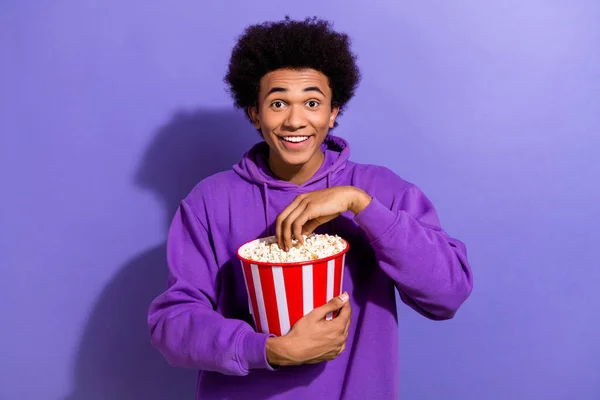 明るい人の肖像歯の笑顔ポップコーンを食べる新しい映画初公開を楽しむ紫色の背景に隔離された — ストック写真