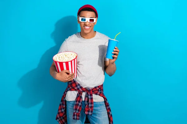 stock image Photo of positive pretty guy dressed grey t-shirt watching 3d movie enjoying snacks isolated blue color background.