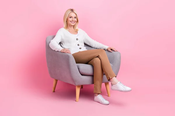 フルサイズの写真の満足かなり高齢者座る椅子良い気分で隔離されたピンク色の背景 — ストック写真