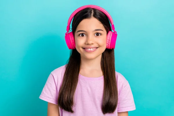 stock image Photo of little kid girl wear pink t-shirt with trendy wireless headphones listen tiktok music playlist isolated on cyan color background.