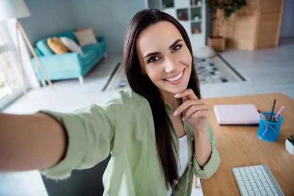 Portrait of gorgeous positive banker lady toothy smile arm finger touch chin make selfie record video spacious office inside.