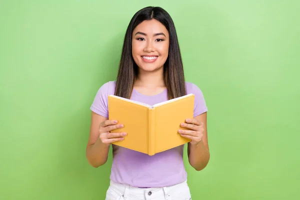 オタクの韓国人女性の写真紫のTシャツを着て文学の本を保持材料は緑の色の背景に隔離された科学知識を楽しむ — ストック写真