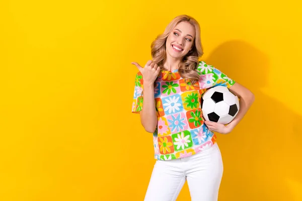 可愛い女の子の写真を着てカラフルなTシャツを保持サッカーボールを示す外観空のスペース黄色の色の背景に隔離 — ストック写真
