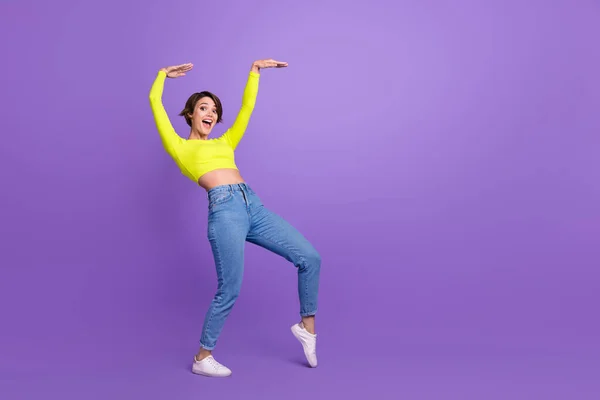 全身上下都是照片 正面漂亮的女士跳着冰凉的舞姿 欢欣鼓舞空旷的空间广告与紫罗兰的背景隔离 — 图库照片