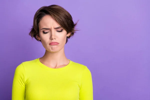 Photo portrait of funny young girl upset looking down dissatisfied bad mood grimacing stress loser isolated on violet color background.