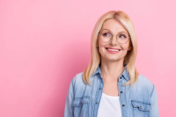 引退した健康な女性の写真笑みを浮かべて横に見える眼のプロモーションは 眼鏡ジーンズシャツ孤立ピンク色の背景を身に着けている — ストック写真