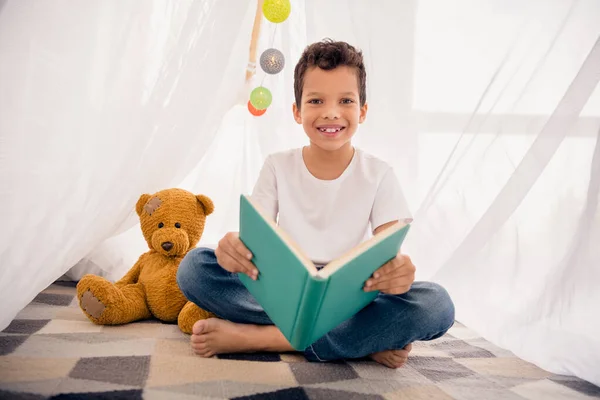 可爱的小男孩的画像搭建露营帐篷看书穿白衬衫浅色现代居室室内设计公寓 — 图库照片