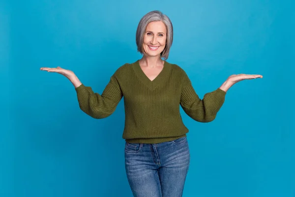 손바닥을 벌리고 매력적 나이든 여성의 사진은 카키색 스웨터를 가지새로운 제품을 — 스톡 사진