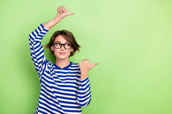 stock image Photo of pretty business lady direct fingers empty space mockup wear spectacles striped shirt isolated green color background.