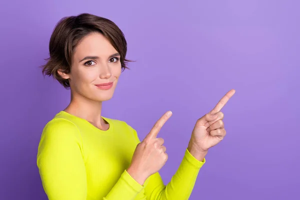 Photo of young woman directing fingers empty space useful tips how solve your financial problems isolated on violet color background.