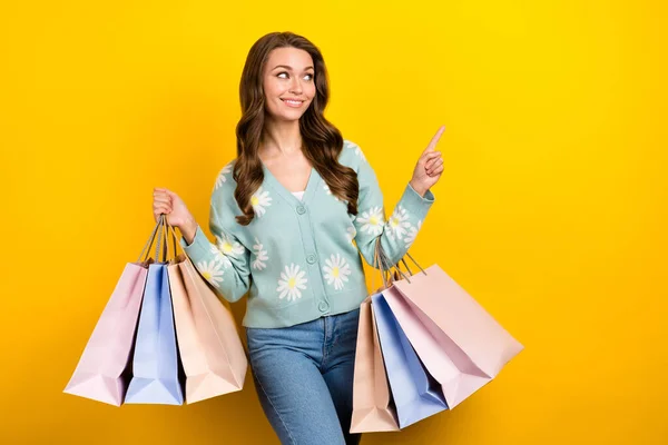 年轻时尚主义购物狂女士拿着购物袋精品店中心的照片 看起来像直接手指空空荡荡的空格广告 孤立在黄色的背景下 — 图库照片