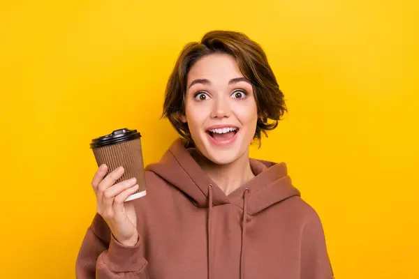 有趣的年轻女士惊讶地抓起纸杯新鲜芬芳卡布奇诺早晨新鲜咖啡与黄色背景分离的照片 — 图库照片