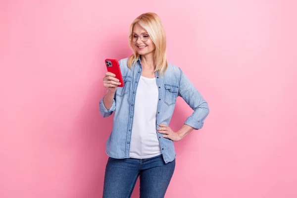 中年ビジネスの女性の不動産業者の写真ピンクの背景に隔離されたスマートフォンで多くの要求を彼女の顧客に答える — ストック写真