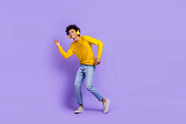 フルサイズの写真の良い気分ハンサムな男服黄色の長袖のヘッドフォンダンス音楽をお楽しみください紫色の背景に隔離された — ストック写真
